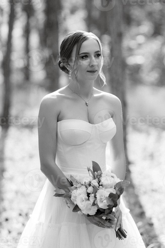 jung Braut im ein Weiß kurz Kleid im ein Frühling Kiefer Wald foto
