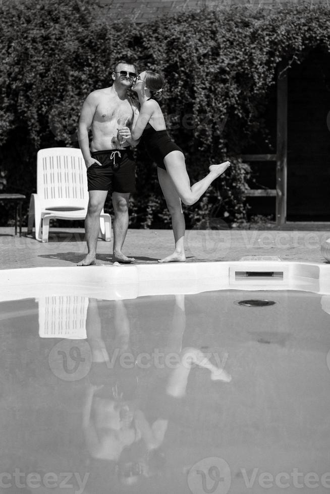 Kerl und ein Mädchen im Baden Anzüge sind entspannend, in der Nähe von das Blau Schwimmbad foto