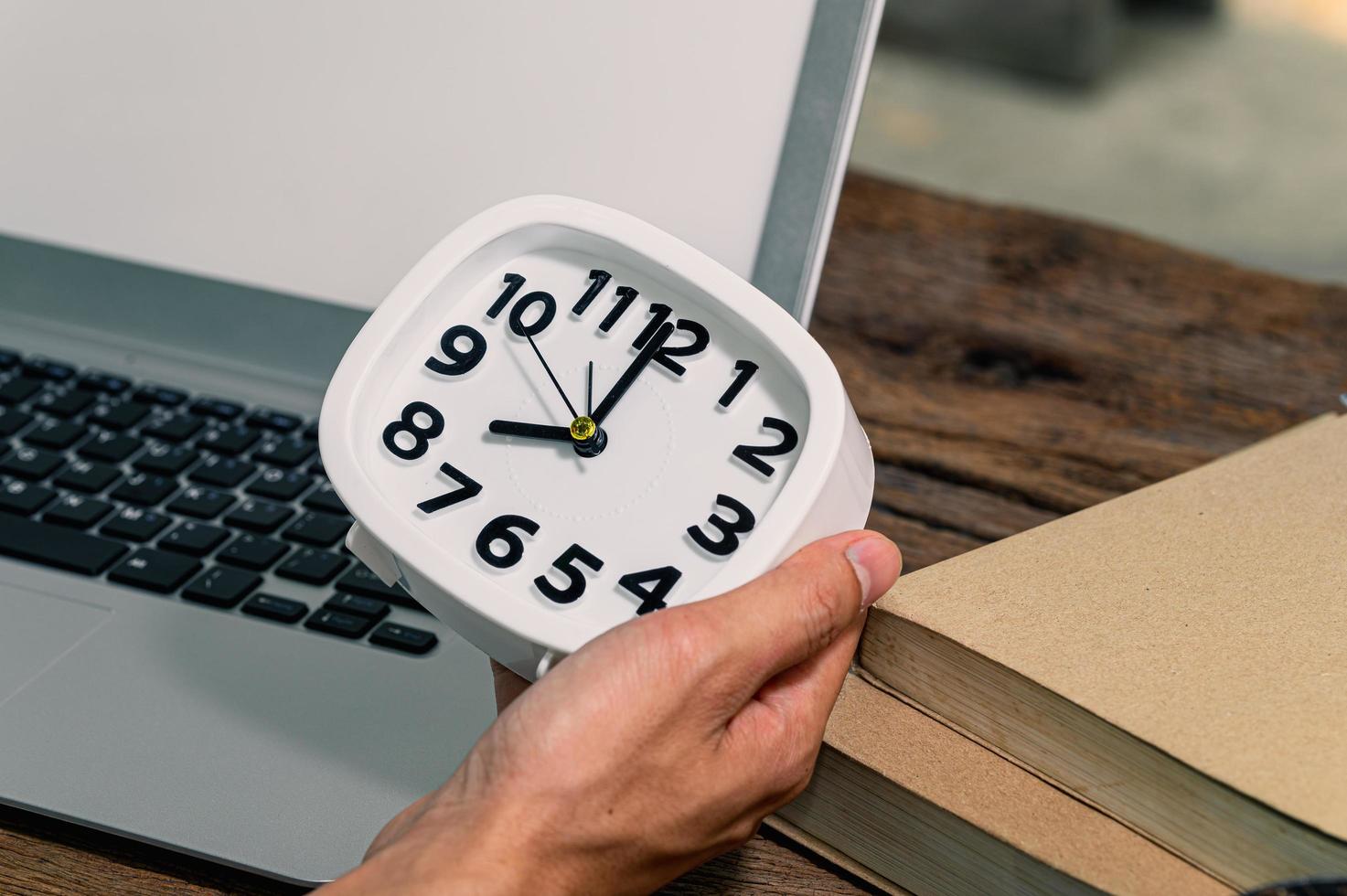 Zeiger hält eine Uhr am Schreibtisch foto