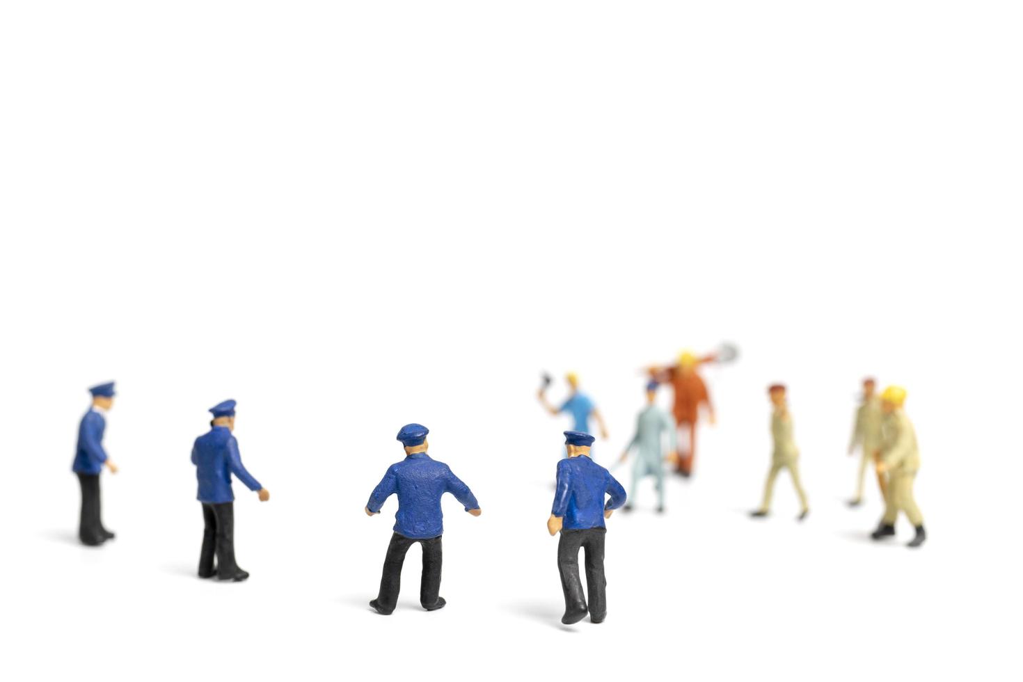 Miniaturpolizei und ein wütender Mob auf weißem Hintergrund foto