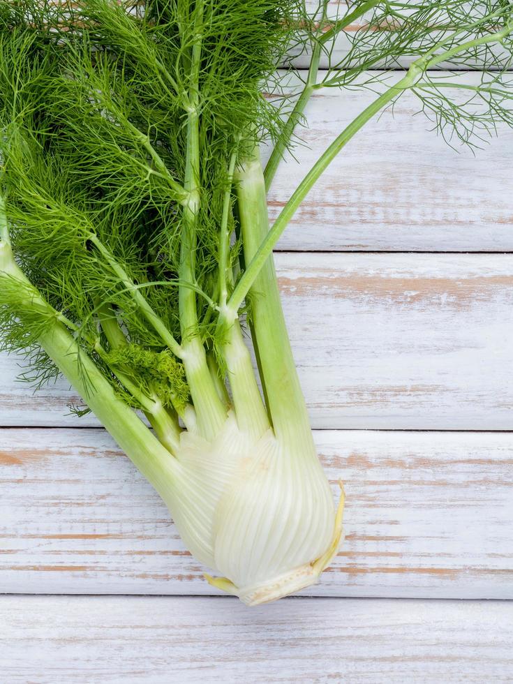 frischer Fenchel auf einem weißen hölzernen Hintergrund foto