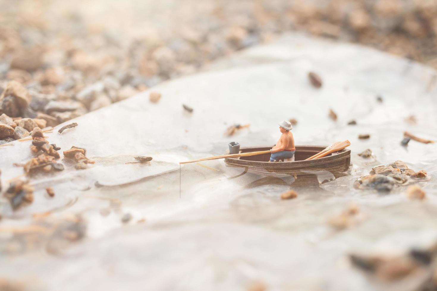 Miniaturfischer, der auf einem Boot fischt foto