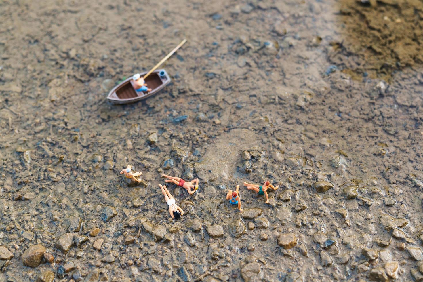 Miniaturmenschen, die Badeanzüge tragen, die auf einem Strand entspannen, Sommerkonzept foto