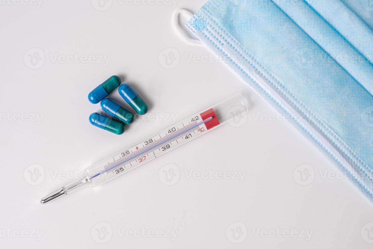 Operationsmaske, medizinische Kapseln und Thermometer foto