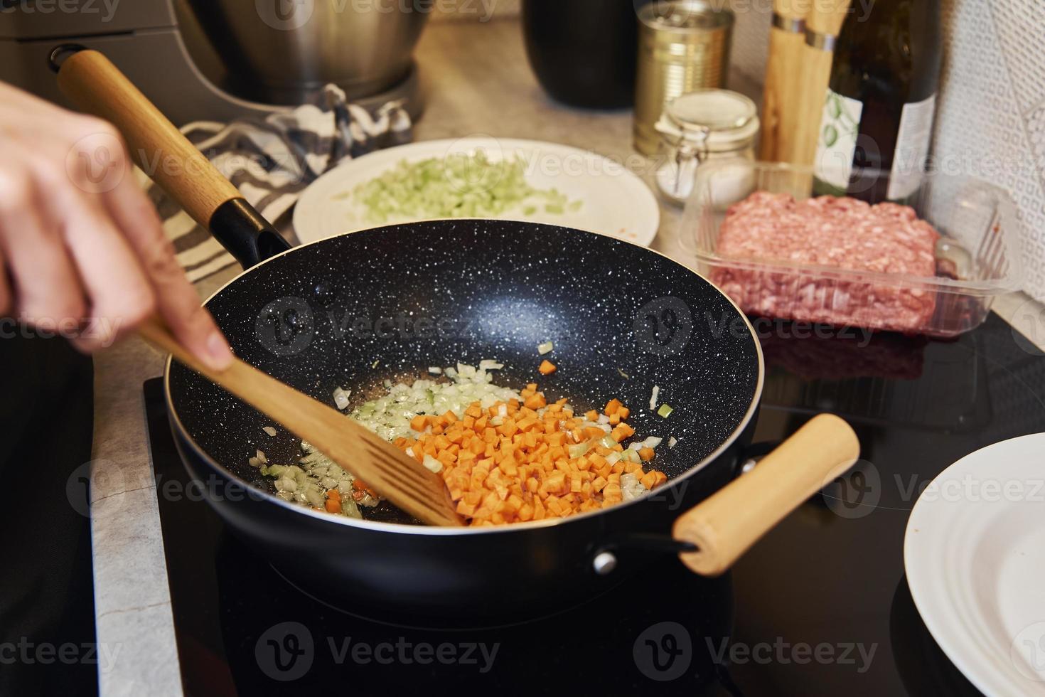 Frau, die Sauce Bolognese in der Küche kocht foto