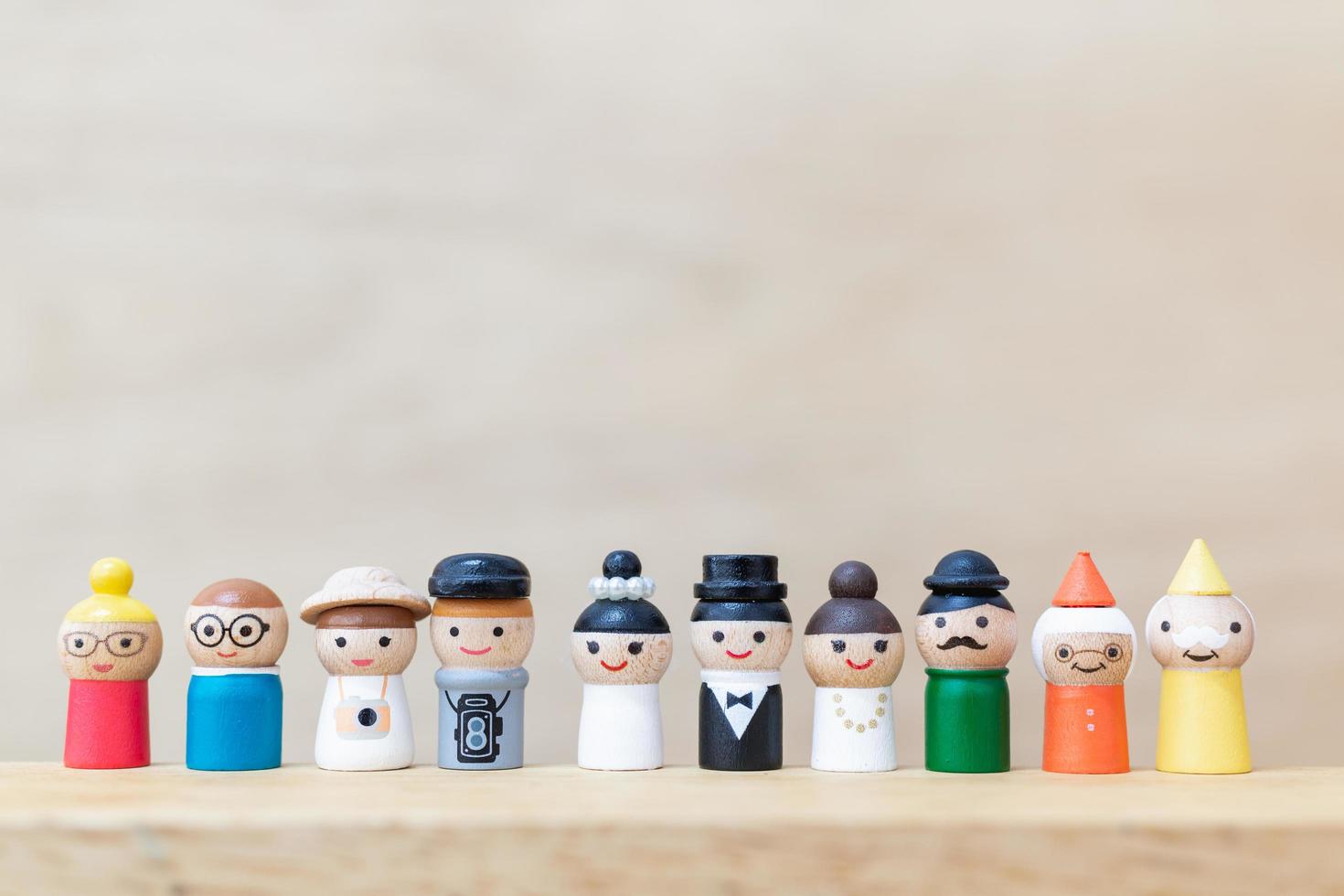 Miniatur-Holzpuppen mit glücklichen Gesichtern auf einem hölzernen Hintergrund foto