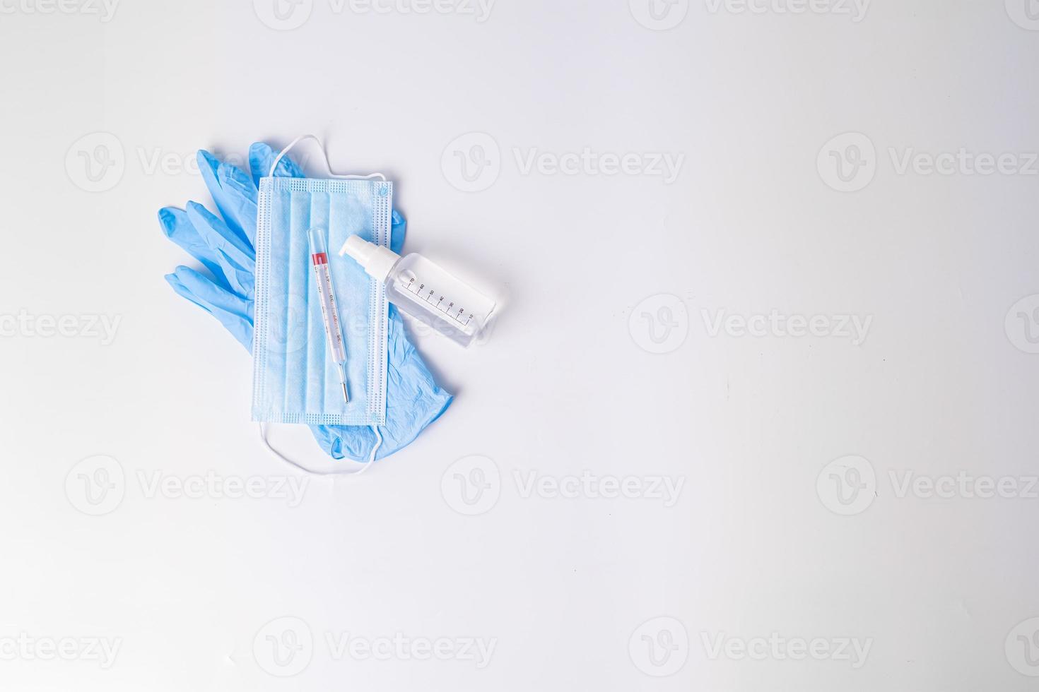 Nitrilhandschuhe mit chirurgischer Maske und Thermometer für hydroalkoholisches Gel foto