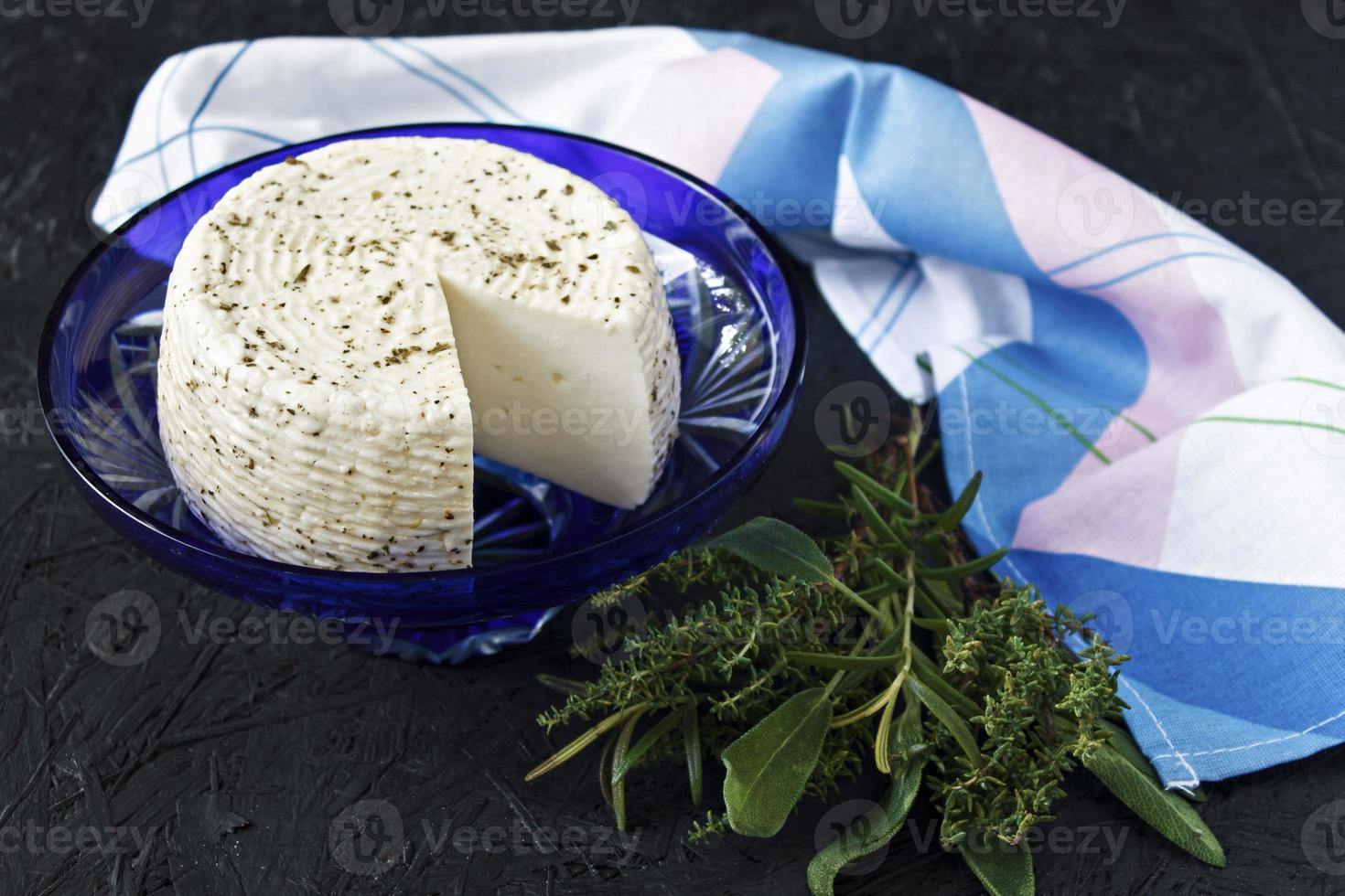 weißer Käse auf einem Teller auf schwarzem Hintergrund und Serviette foto