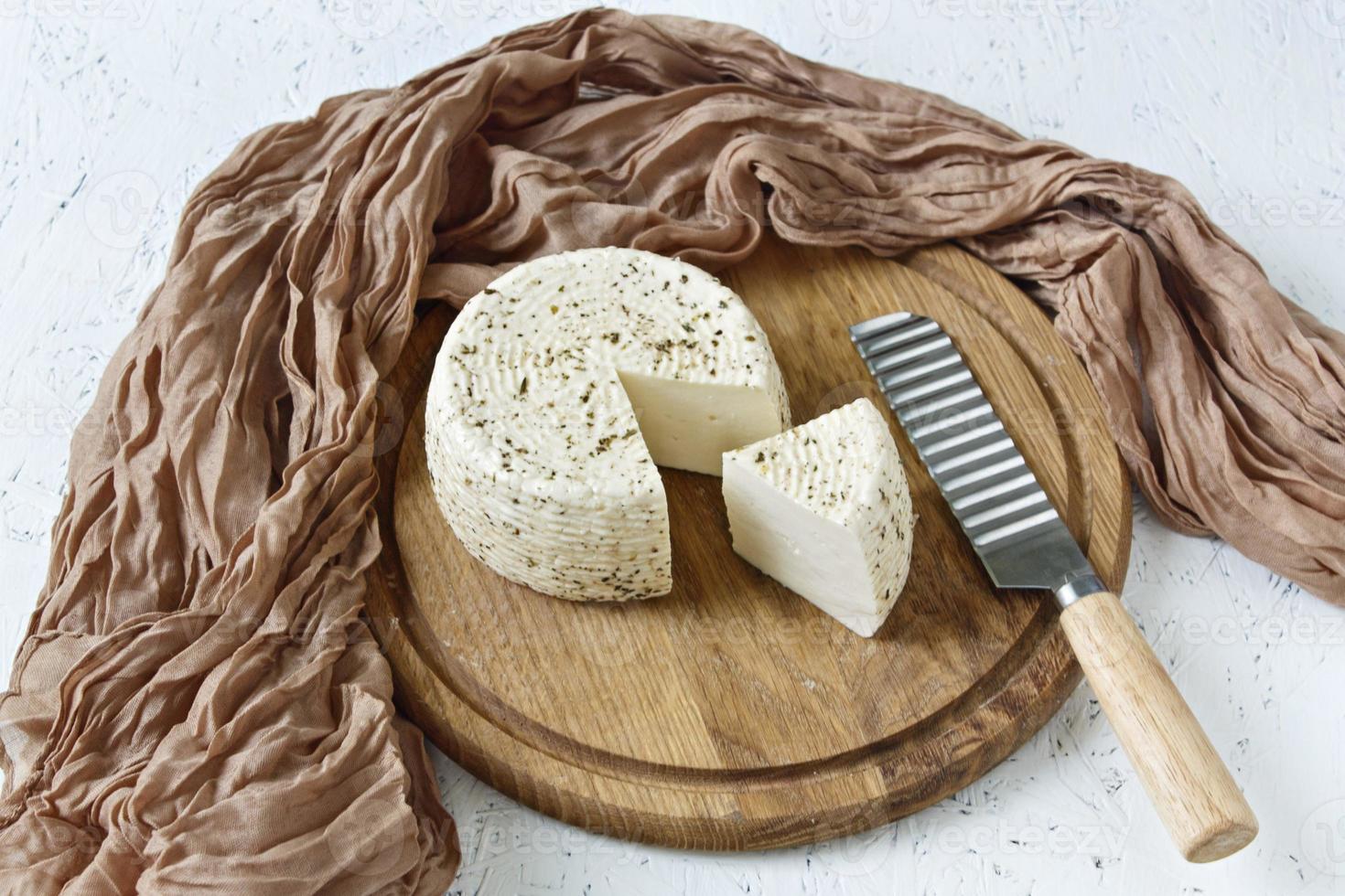 weißer Käse auf einem Holzbrett auf weißem Hintergrund foto