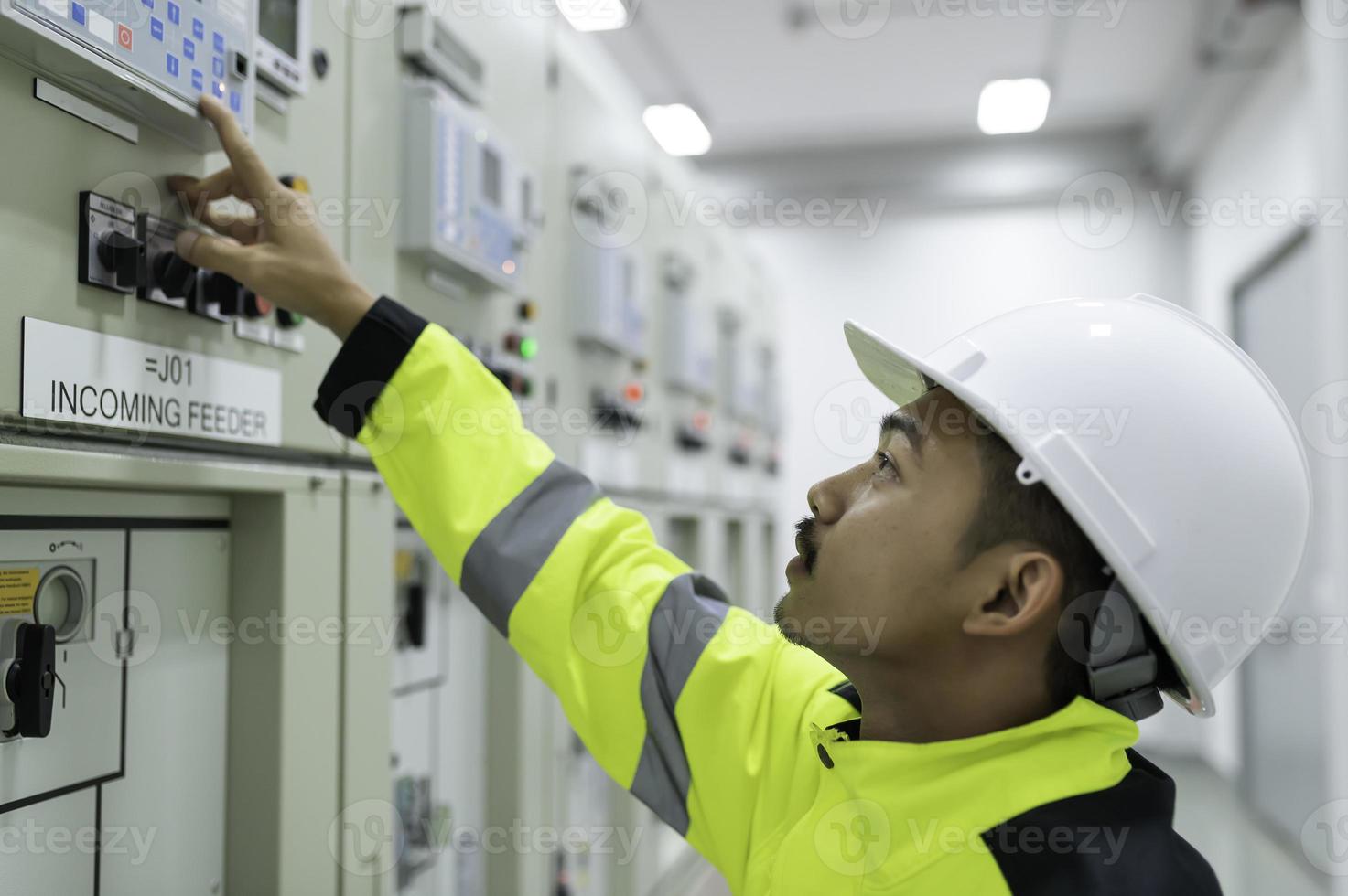 elektroingenieurmann, der die spannung am stromverteilerschrank im kontrollraum überprüft, jährliche vorbeugende wartung, thailand-elektriker, der im unternehmen arbeitet foto