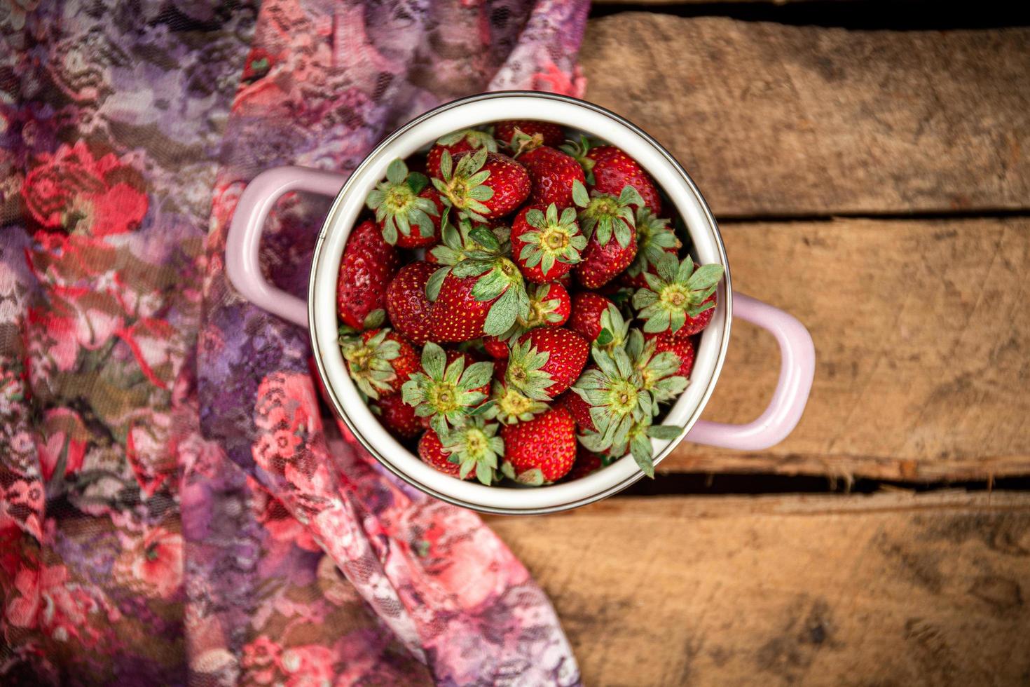 Erdbeeren in einer Schüssel auf einem Holztisch foto