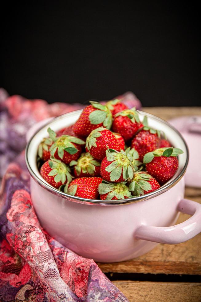 Erdbeeren in einer Schüssel auf einem Holztisch foto