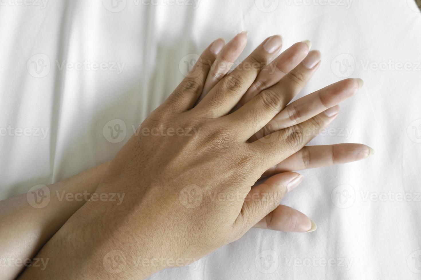ein Foto von ein Mann und Frau Hände haben Sex auf ein Bett. machen Liebe.