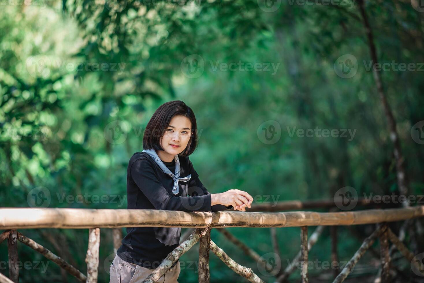 Protrait junge Frau, die beim Camping im Wald schöne Natur sieht foto