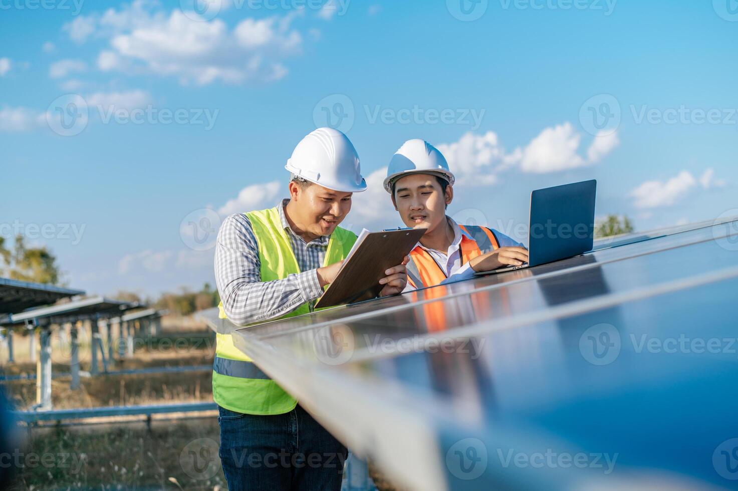 Zwei Ingenieure diskutieren während der Arbeit im Solarpark foto