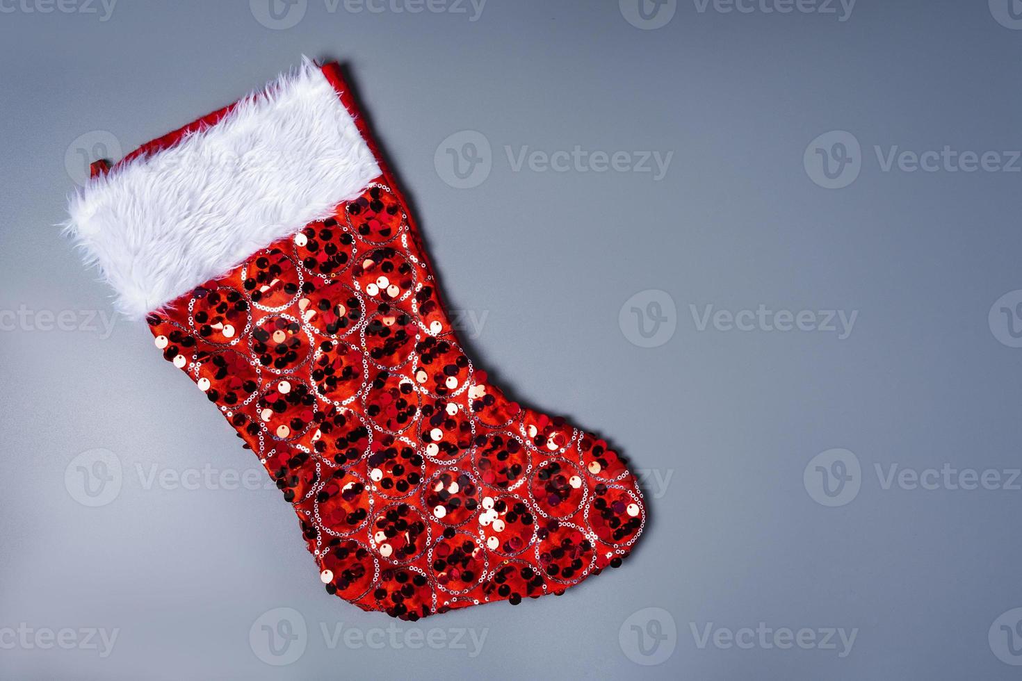 Weihnachten Strumpf, rot glänzend Schuh zum Weihnachten Geschenke auf grau Hintergrund, Überraschung foto