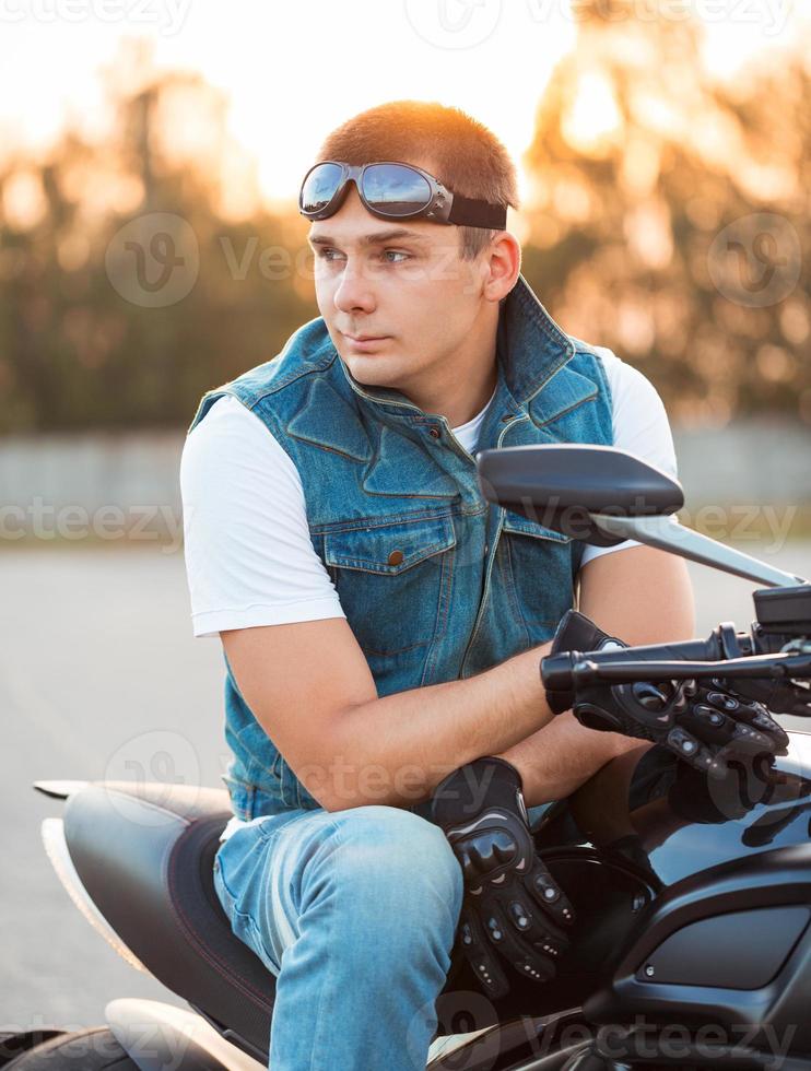 Biker Mann Sitzung auf seine Motorrad draußen foto