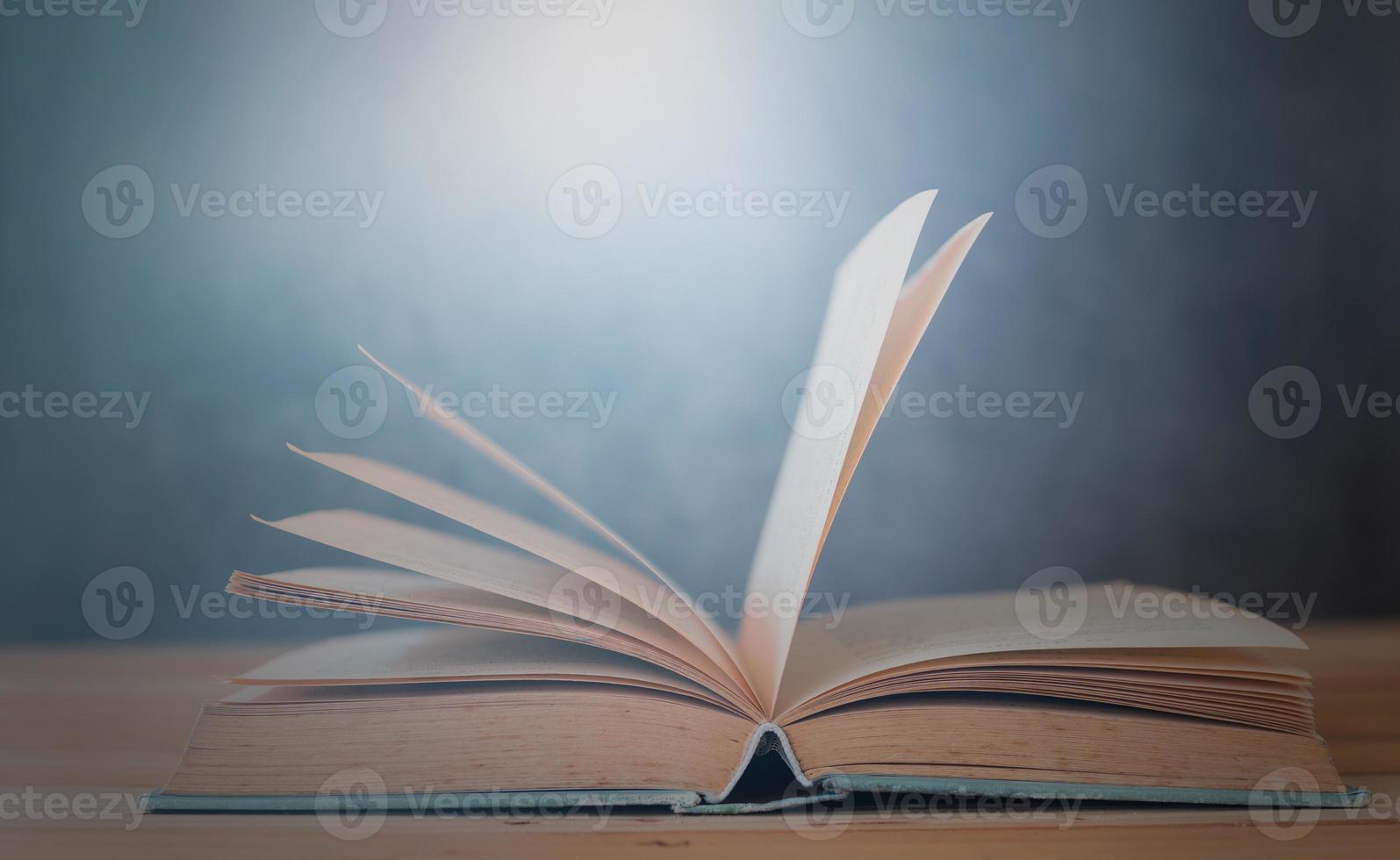 offenes Buch auf Holztisch mit blauem Hintergrund foto