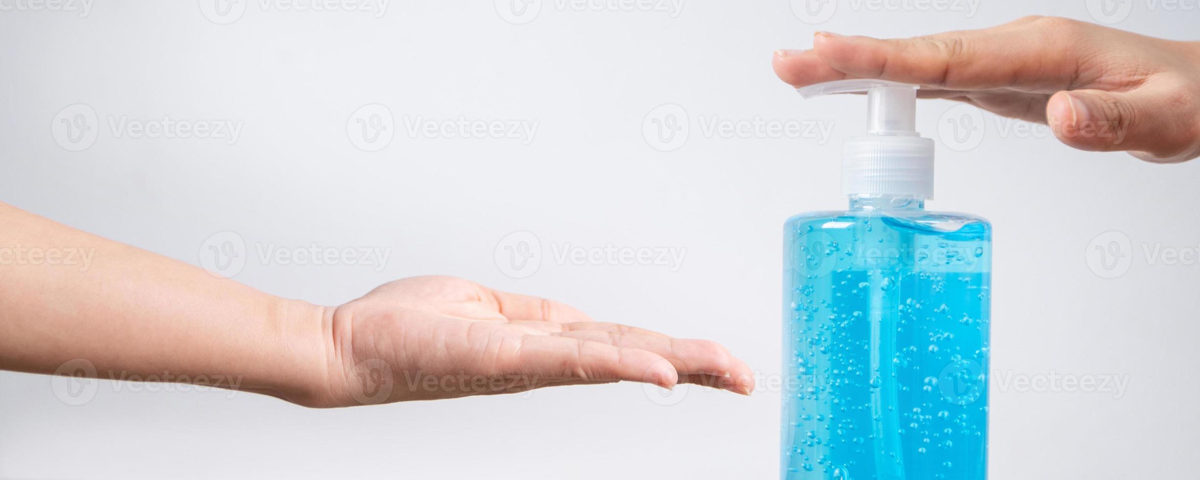 Hände mit blauer Desinfektionsflasche foto