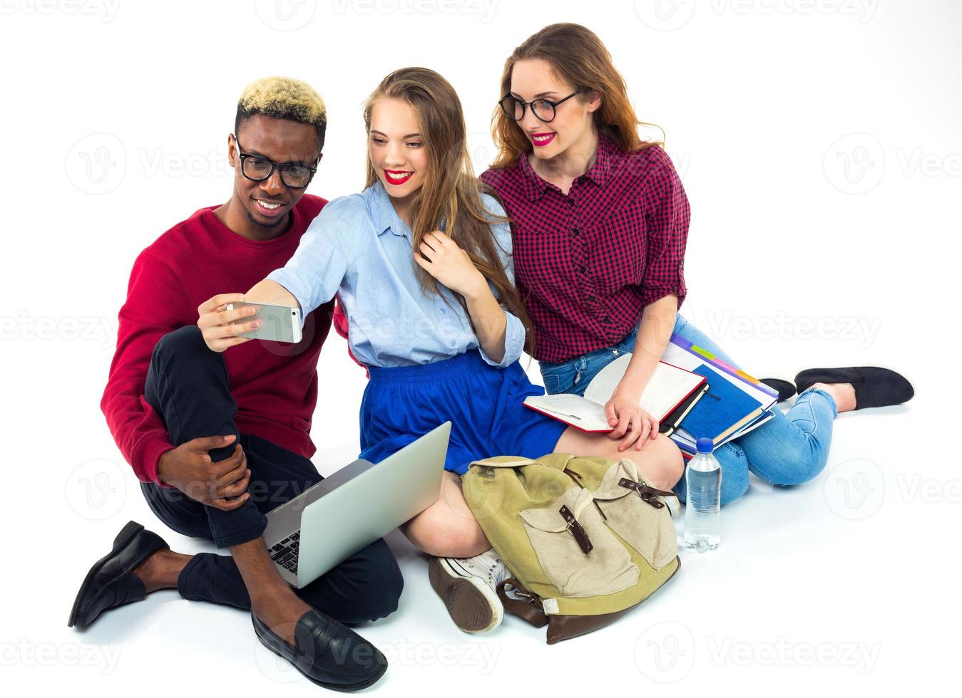 drei glücklich Studenten mit Bücher, Laptop, Taschen und macht Selfie foto