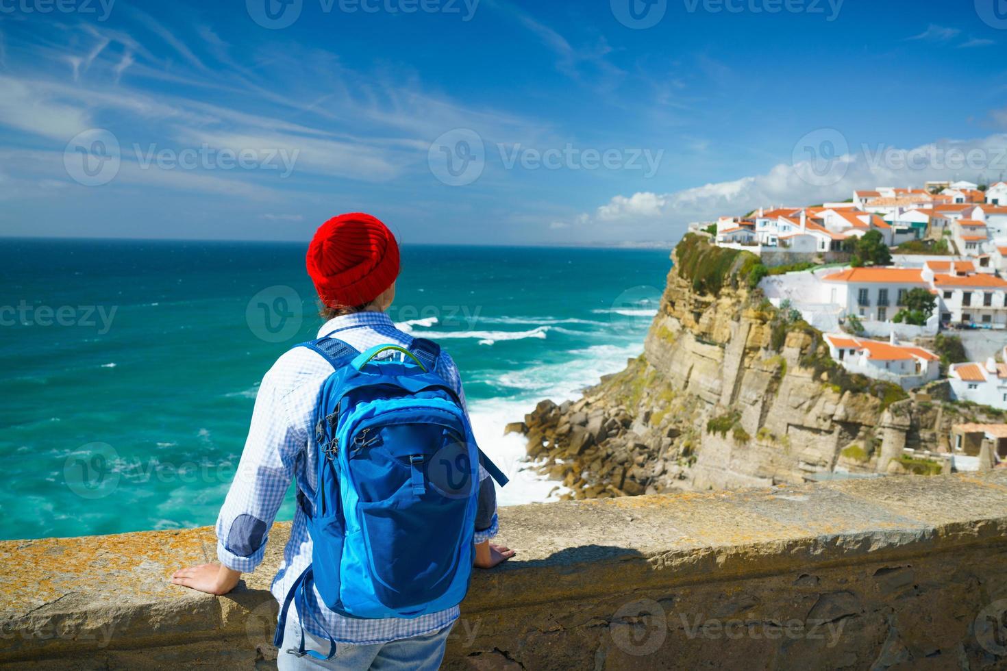 Frau mit ein Rucksack genießt ein Aussicht von das Ozean Küste in der Nähe von azenhas tun beschädigen, Portugal foto