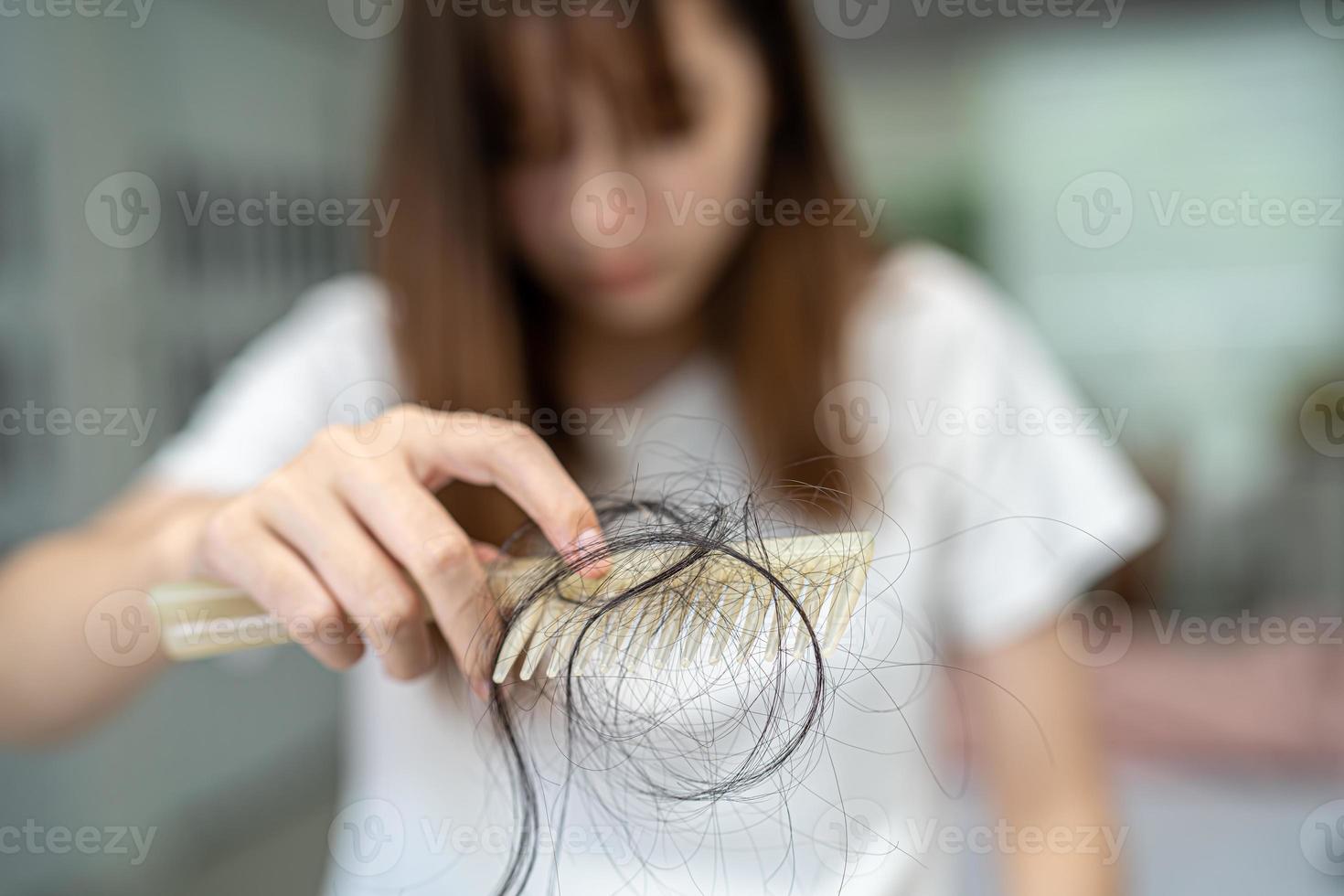 asiatische Frau hat Probleme mit langem Haarausfall an der Kammbürste. foto