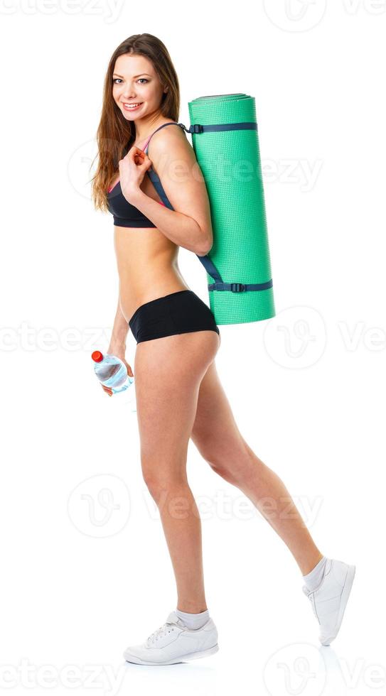 schön Sport Frau mit Matte zum Fitness und Flasche von Wasser isoliert auf Weiß foto