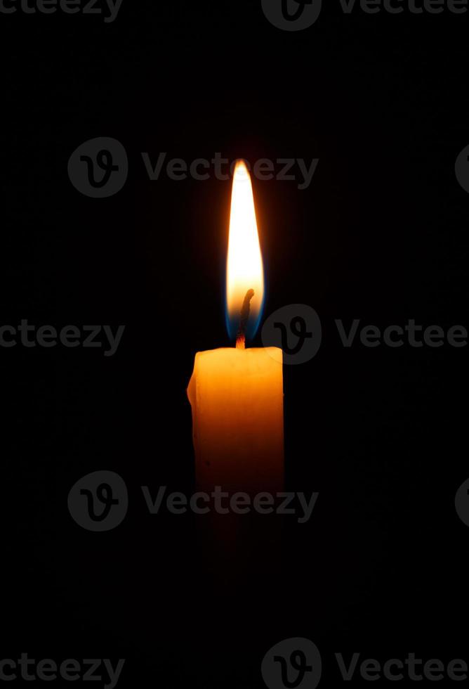 einer Licht Kerze Verbrennung hell im das schwarz foto