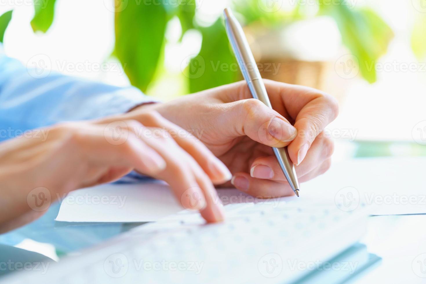 Frau Büro Arbeiter mit Stift im Hand Tippen auf das Tastatur foto