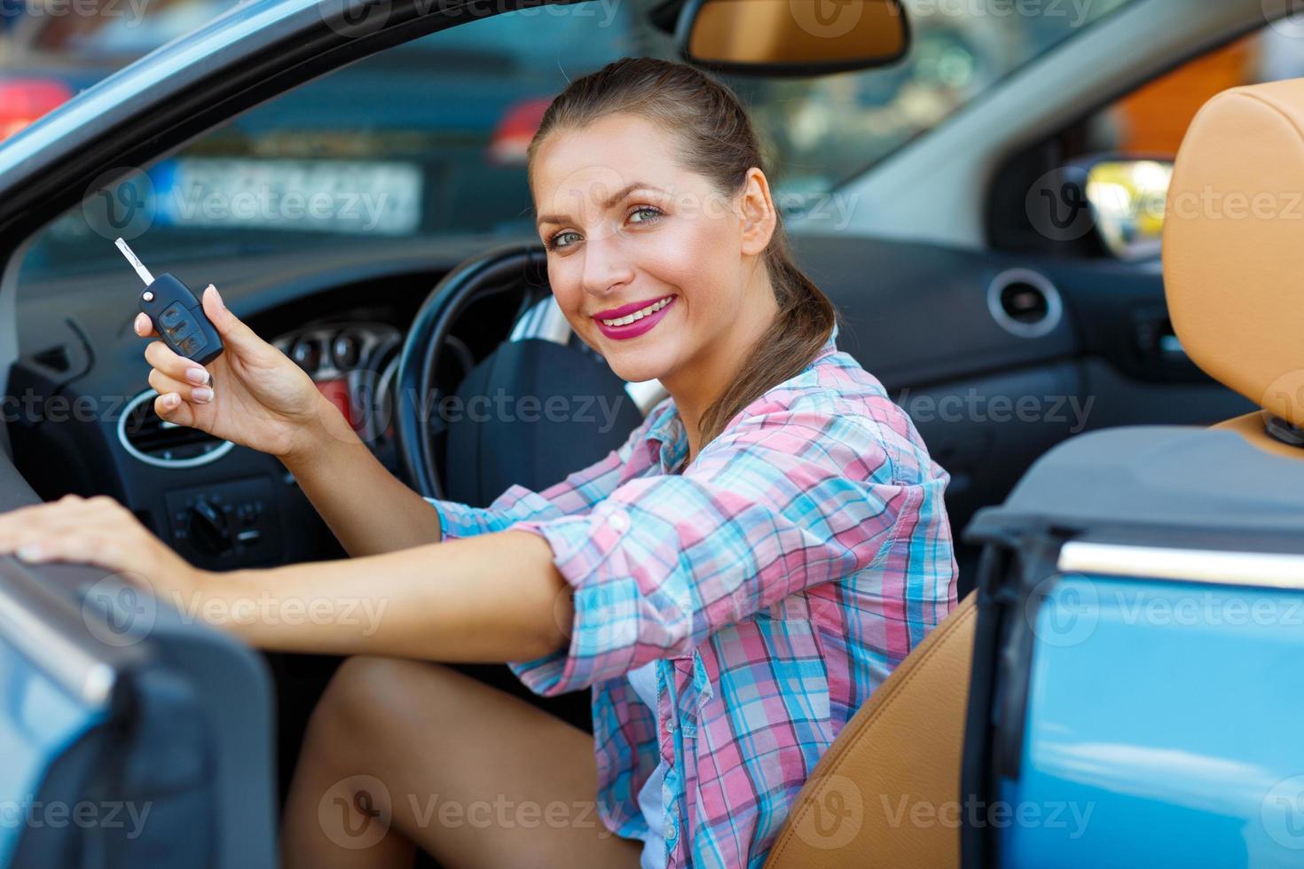 jung Frau Sitzung im ein Cabrio Auto mit das Schlüssel im Hand - - Konzept von Kauf ein benutzt Auto oder ein Vermietung Auto foto
