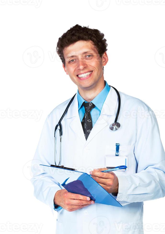 jung lächelnd Arzt Schreiben auf ein Patienten medizinisch Diagramm auf Weiß foto