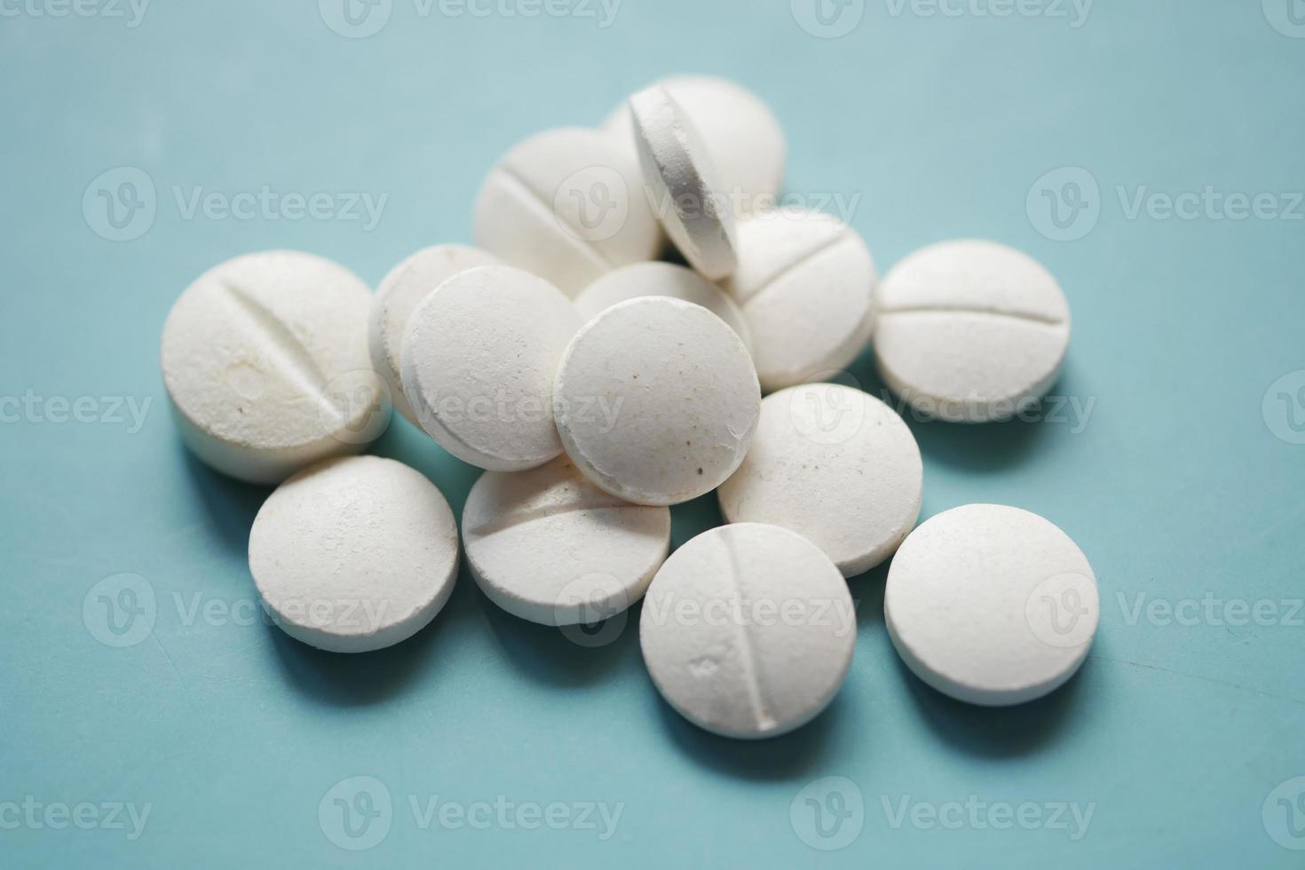 Weiße medizinische Pillen, die auf Rosa verschüttet werden foto