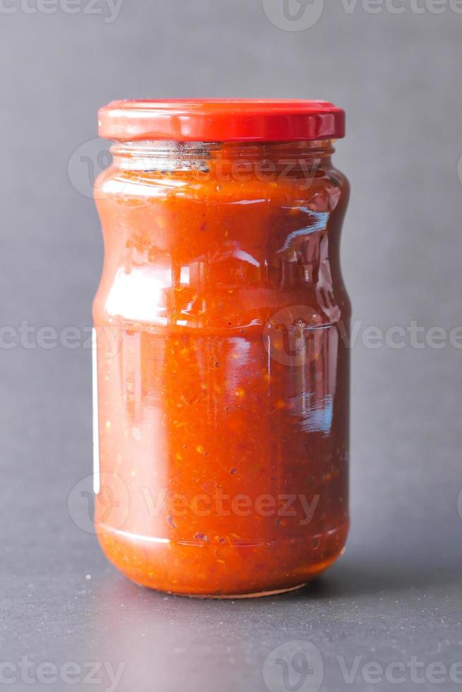 Tomatensauce in einem Glas mit frischen Tomaten auf dem Tisch foto