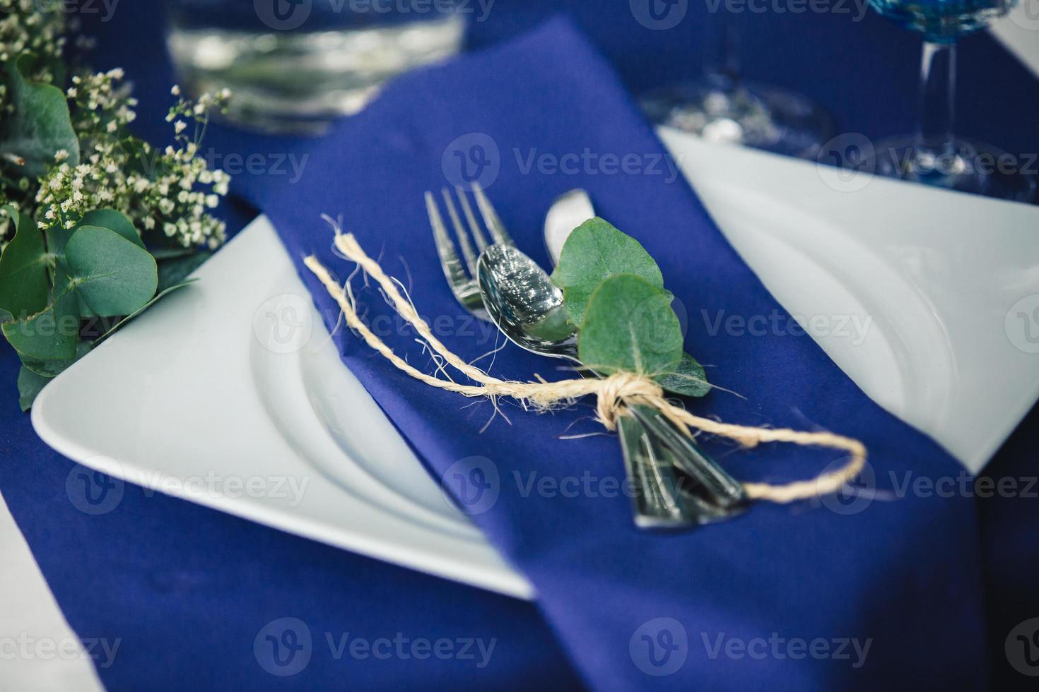 Dekor. Einzelheiten. Komposition. Hochzeit Dekorationen im Blau Töne. auf das hölzern Tabelle im das Wald Dort ist ein Grün, Besteck, Eukalyptus foto