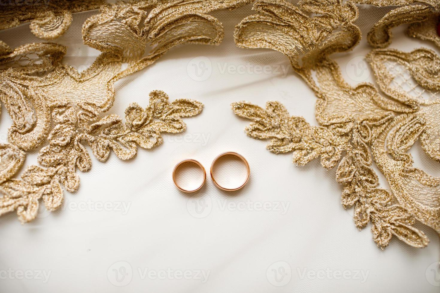 Paar von golden Hochzeit Ringe Über Schleier mit Spitze. Hochzeit Zubehör. selektiv Fokus foto