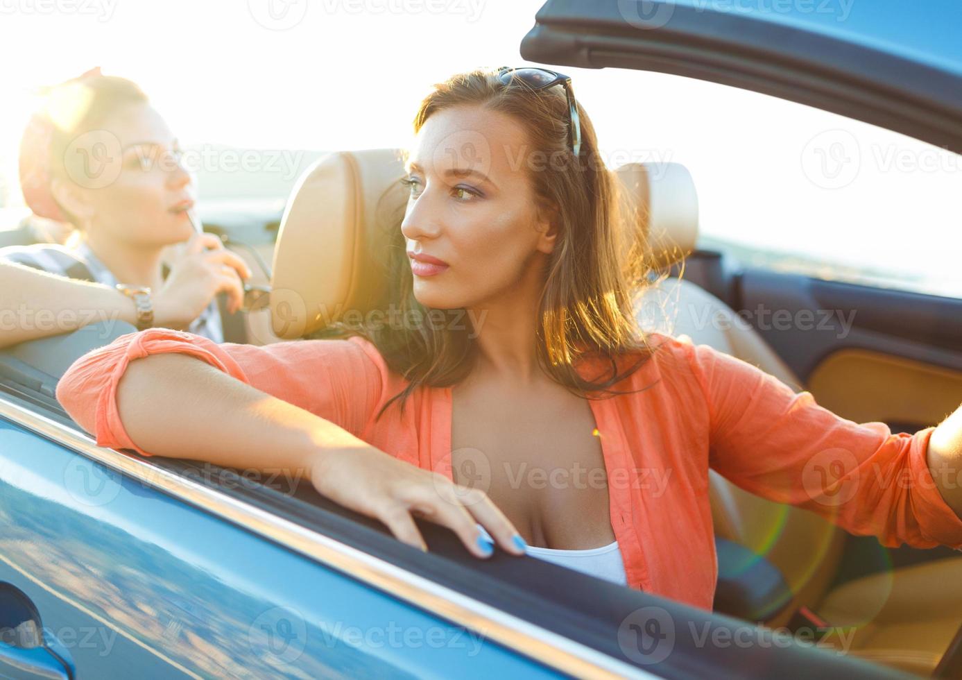 zwei jung Mädchen Fahren ein Cabriolet foto