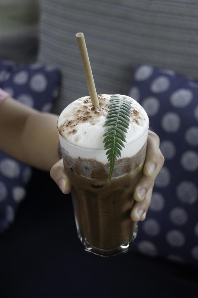 Eiskaffeegetränk mit Farnblatt verziert foto