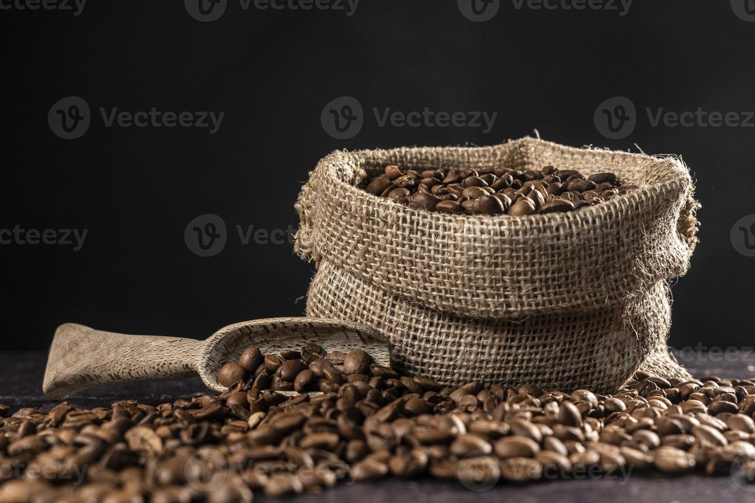 geröstet Kaffee Bohnen mit klein Sack und hölzern Scoop foto