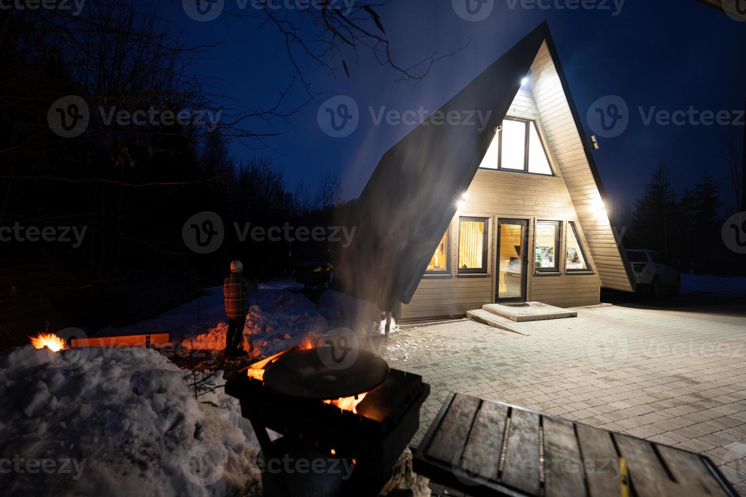 Holz gefeuert Grill gegen Dreieck Land Haus beim Nacht. foto