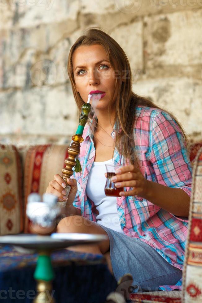 Frau Rauchen ein Huka und Trinken Tee im ein Cafe, Istanbul, Truthahn foto