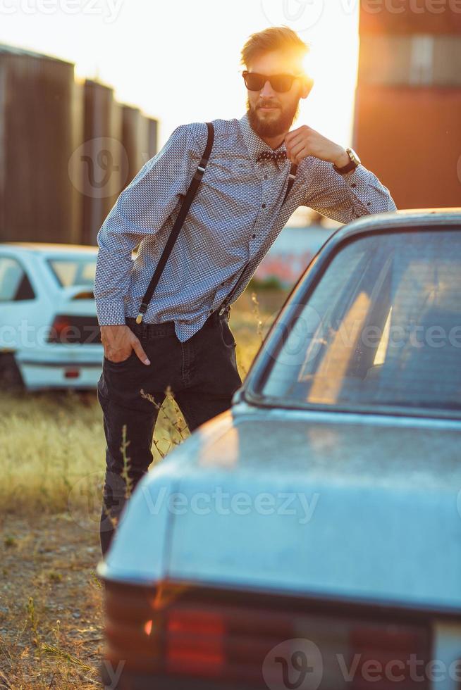 jung gut aussehend stilvoll Mann, tragen Hemd und Krawatte mit alt Autos foto