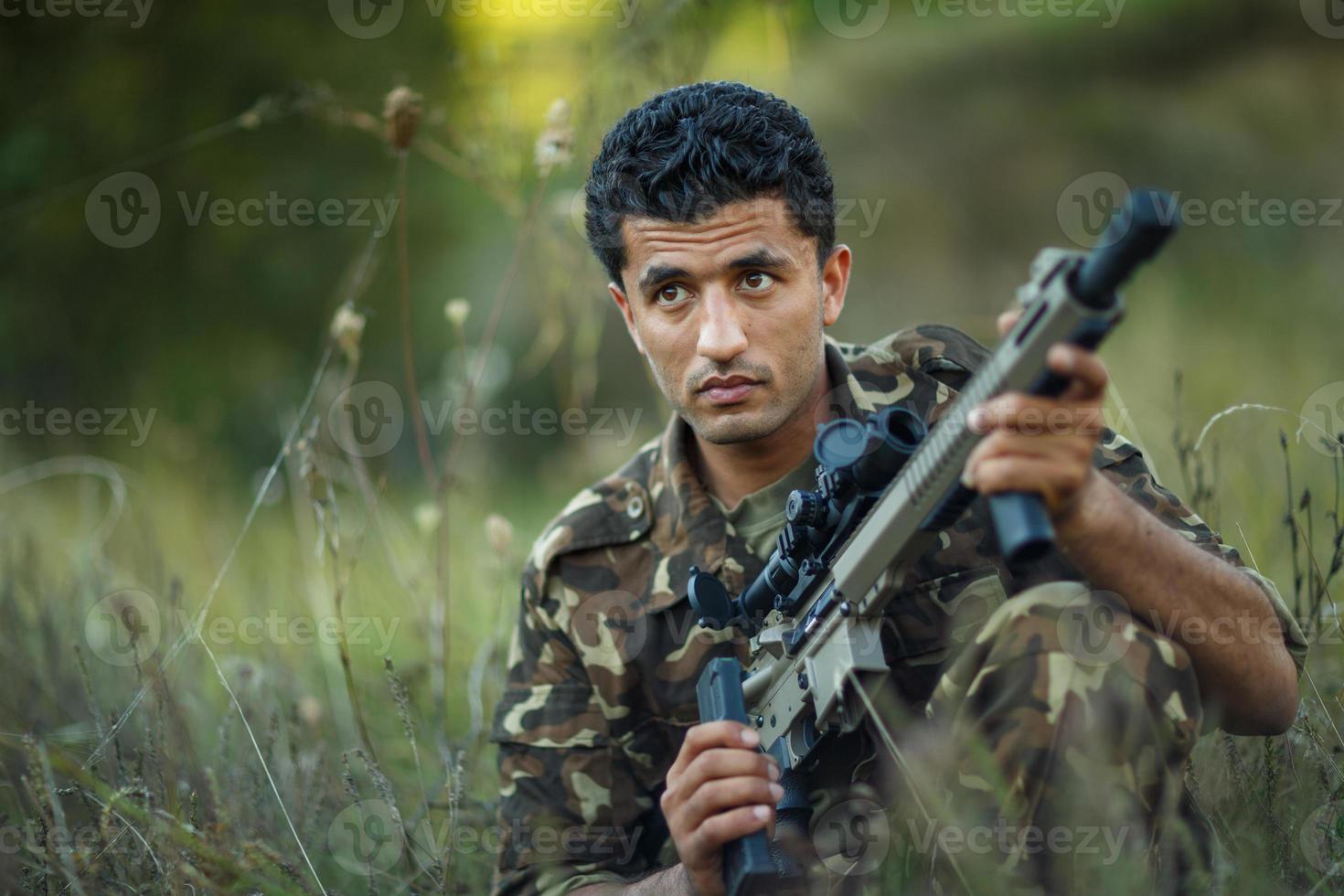 Mann von arabisch Staatsangehörigkeit im tarnen mit ein Schrotflinte foto