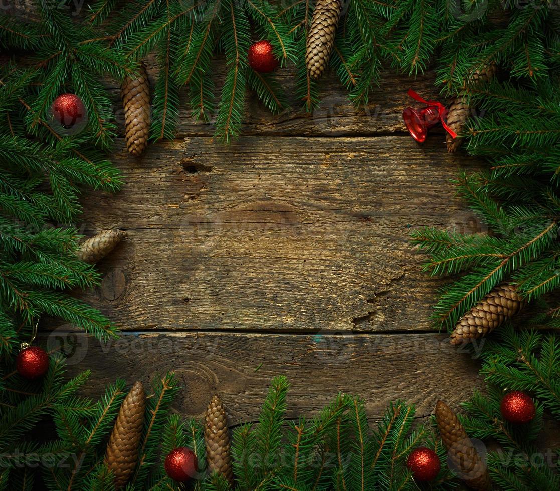 Weihnachten Baum Geäst mit Zapfen und Weihnachten Dekorationen auf hölzern Textur bereit zum Ihre Design foto