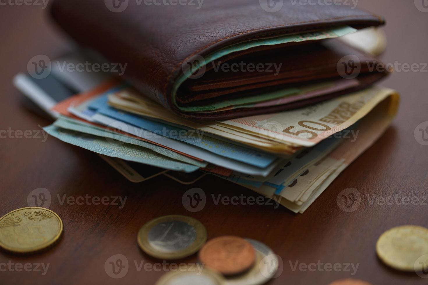 braun Brieftasche mit Euro Geld Innerhalb und Münzen, Anerkennung Karten in der Nähe von es foto