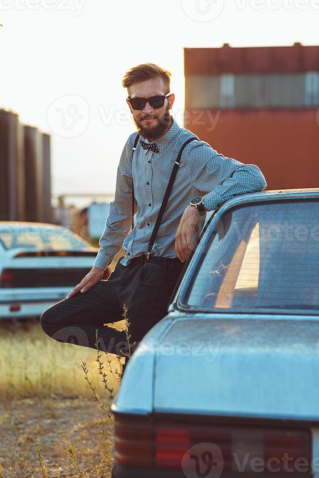 jung gut aussehend stilvoll Mann, tragen Hemd und Krawatte mit alt Autos foto