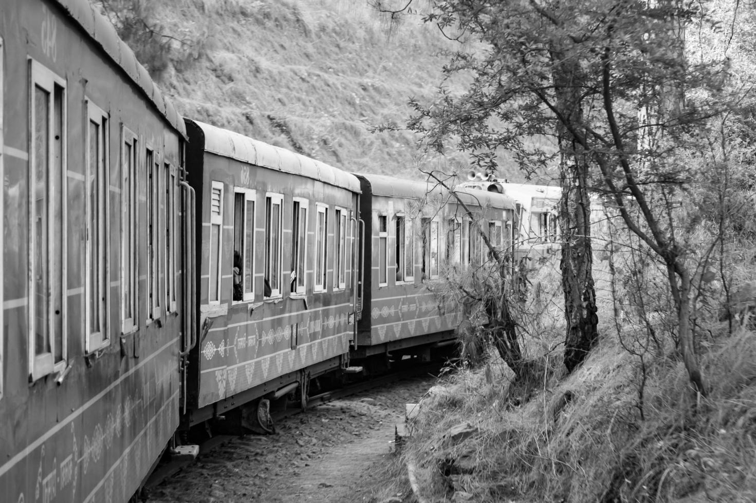 Spielzeugeisenbahn, die sich auf Berghängen bewegt, schöne Aussicht, ein Seitenberg, ein Seitental, das sich auf der Eisenbahn zum Hügel bewegt, inmitten grüner Naturwälder. spielzeugeisenbahn von kalka nach shimla in indien, indischer zug foto