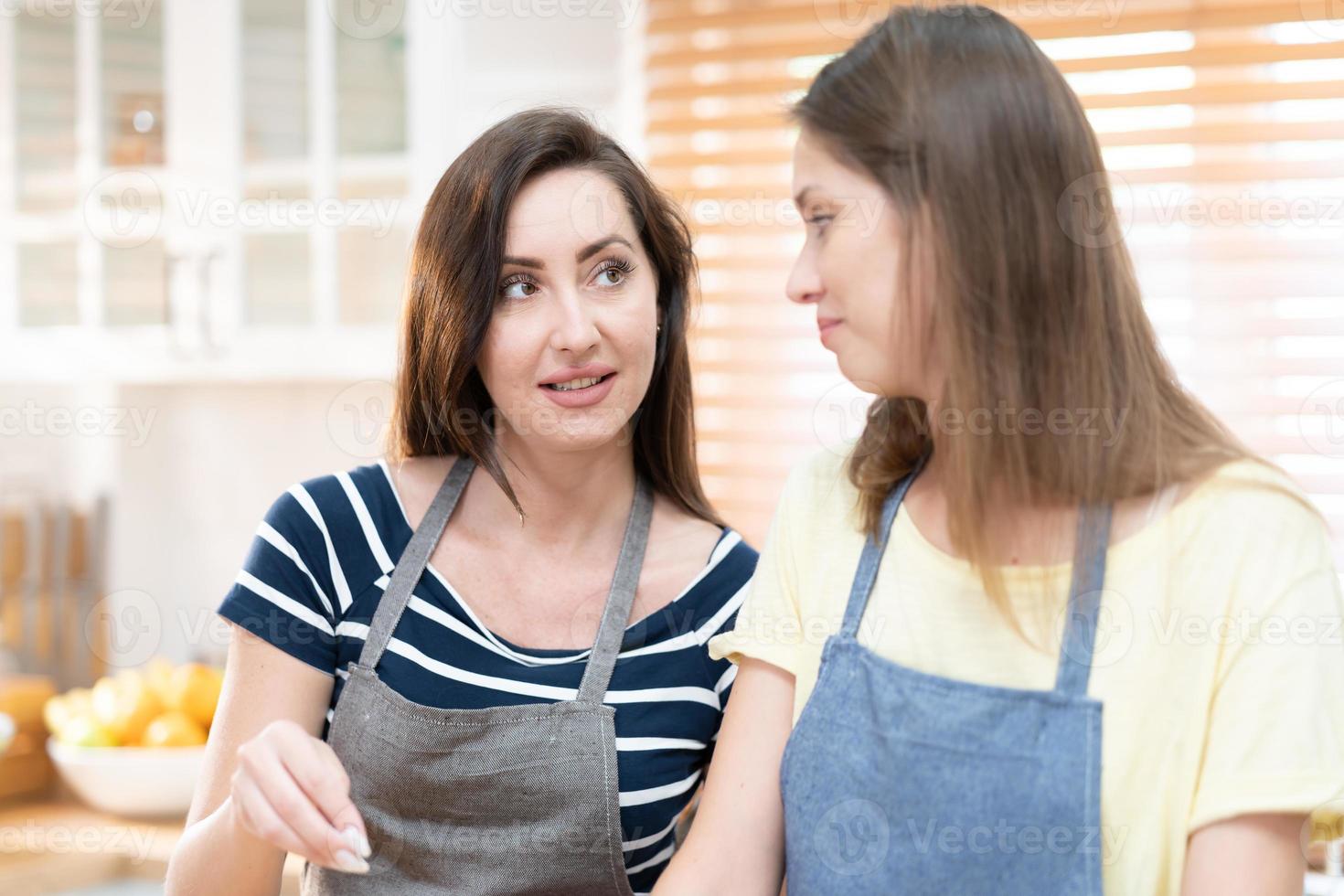 zwei kaukasisch Frauen Kochen Pizza zusammen im das Küche. das Konzept von hausgemacht Essen und lgbt Beziehungen. Familie und Vielfalt Konzept. lgbt. foto