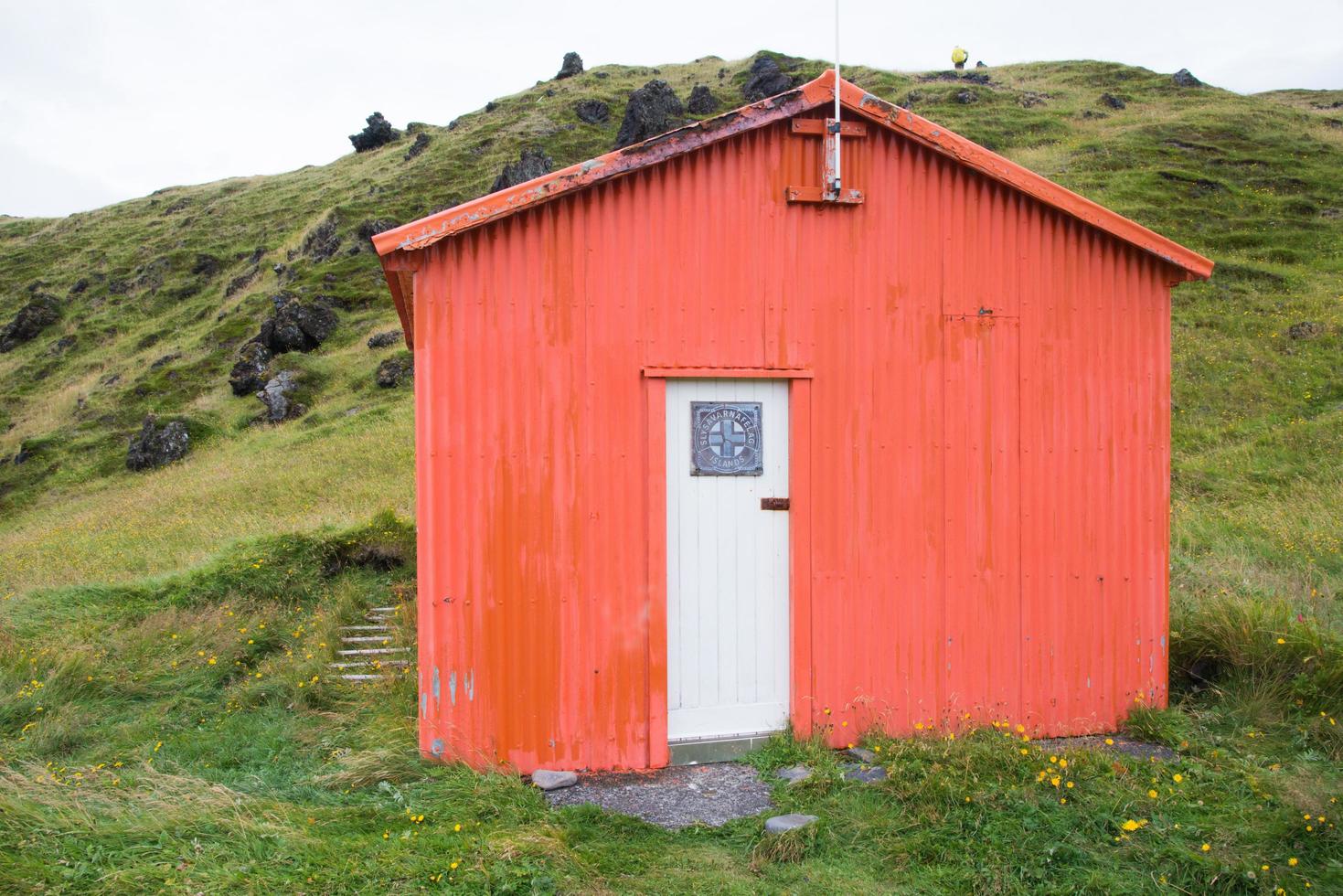 hölzern Hütte im Orange Farbe und Weiß Tür. Island foto
