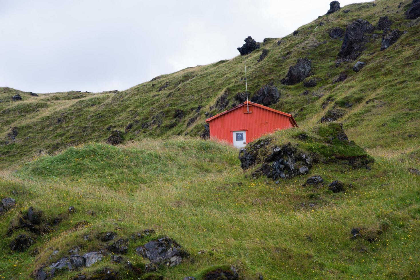 schön Landschaft mit Grün Hügel und klein hölzern Hütte. Island foto