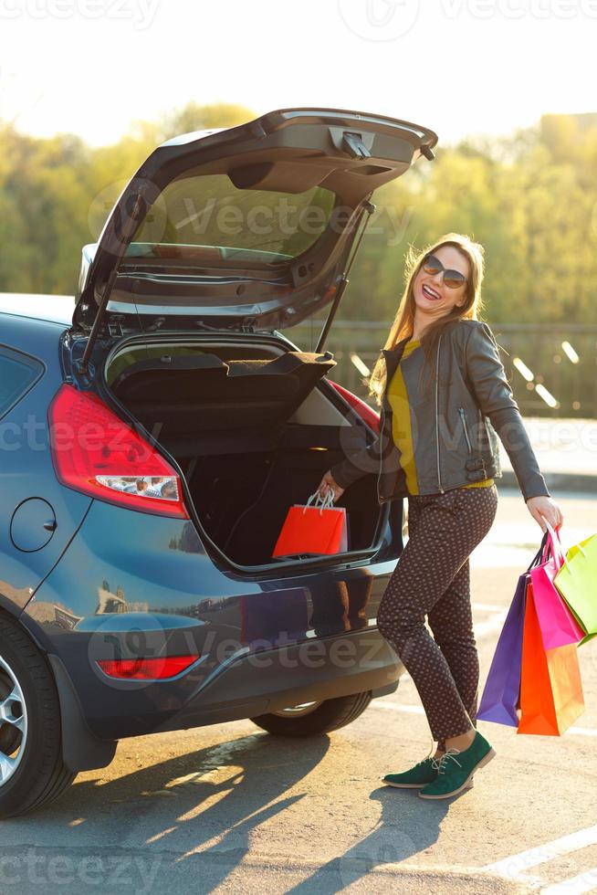 kaukasisch Frau Putten ihr Einkaufen Taschen in das Auto Kofferraum foto